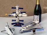 une bouteille de champagne, une maquette de navette spatiale et une navette spatiale