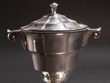 an antique silver plated sugar bowl with a lid on a black background