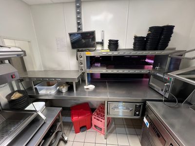 une grande cuisine avec de nombreux plans de travail en inox