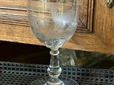 a glass of water sitting on a table with a wooden cabinet in the background