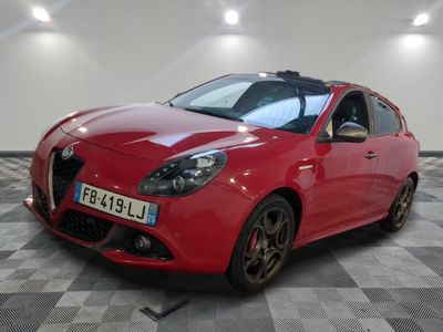la voiture rouge est garée sur un sol en damier dans le garage