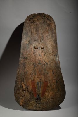 an old wooden object on a white surface with a shadow