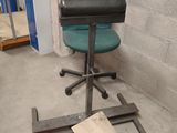 une chaise verte posée sur un piètement métallique dans une pièce
