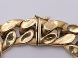 an image of a gold bracelet on a white surface