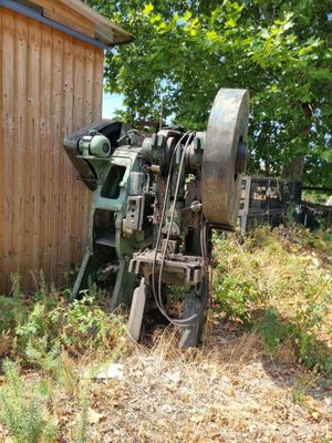 a machine that is sitting in the grass by a building