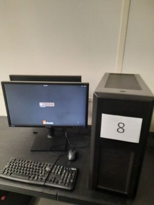un ordinateur de bureau posé sur une table avec un clavier et une souris