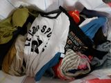 a pile of clothes that is on a bed