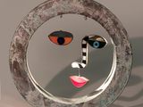 a sculpture of a woman ' s face in a circular mirror