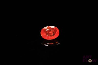 un diamant rouge dans l'obscurité, sur fond noir