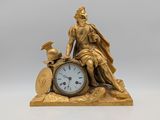 une statue en or représentant un homme assis au sommet d'une horloge