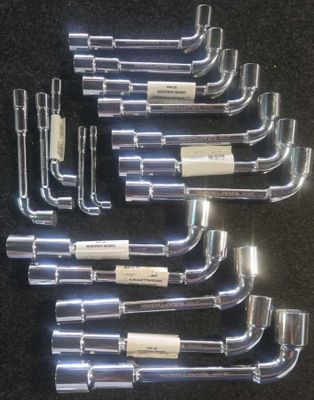 un lot de six raccords de tuyauterie en acier inoxydable posés sur un fond noir