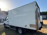 Le camion blanc est garé sur la pelouse devant une maison.