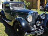 a vintage car that is parked in the grass