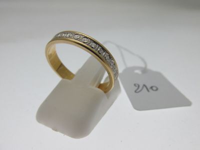 gros plan d'une bague en or avec des diamants sur une surface blanche