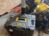 Des outils jaunes et noirs sont posés par terre dans une pièce