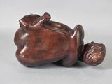 a close up of a figurine of a frog laying on its back