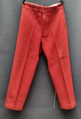 un pantalon rouge suspendu à un cintre accroché au mur