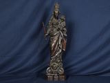une statue représentant une femme tenant une épée, sur fond bleu