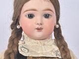 a doll with braid hair wearing a black dress