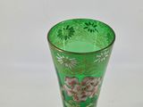 a green glass vase with a floral design on it