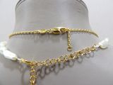 a close up of a mannequin with a gold chain and pearls
