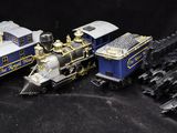 three toy trains sitting next to each other on a black surface