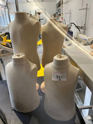 three mannequins sitting on a table in a room