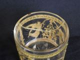 a glass with a gold design on it on a black surface