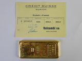 un lingot d'or et une carte de crédit posés l'un à côté de l'autre sur une table