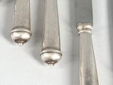 four knives and a knife rest on a white surface