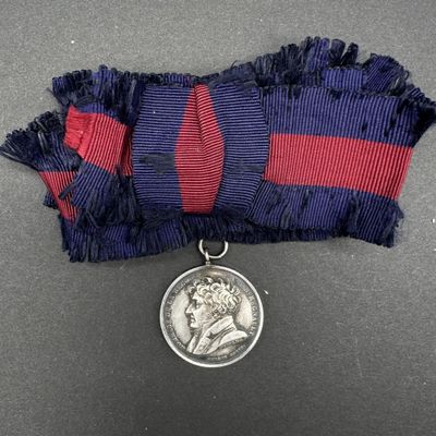une image représentant une médaille en argent suspendue à un ruban