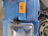 a small blue machine with a yellow tag on it