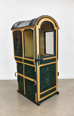 une photo d'une petite vitrine verte et dorée dans une pièce