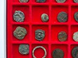 a red display case with a lot of ancient coins in it