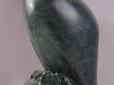 an image of a statue of a bird sitting on top of a green marble block