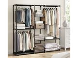 a black metal shelving with clothes hanging on it in front of a white wall