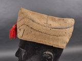 a brown hat with a red tassel on top of it