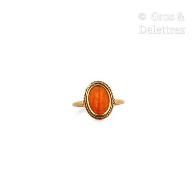une image représentant une bague en or avec une pierre orange au centre