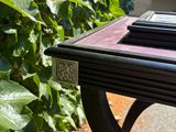 a small table with a book on it in the middle of a garden