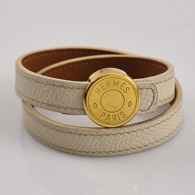 leather bracelet with a gold button on a white background