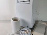 a white air conditioner sitting on a table next to a cup of coffee