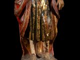 an old statue of a man with a hat and a robe