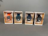 trois montres sont exposées dans une vitrine posée sur une surface grise