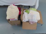 two boxes of diapers sitting on the floor next to a table