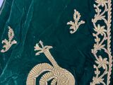 an image of a close up of a green dress with a peacock on it