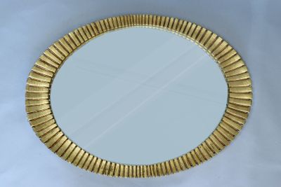 miroir avec un cadre doré sur fond blanc