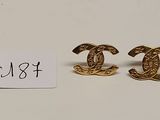 deux paires de boucles d'oreilles Chanel dorées, avec leur étiquette de prix