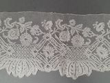une image représentant une dentelle blanche ornée de fleurs et de feuilles