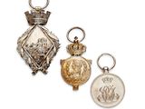 deux médailles d'argent et d'or ainsi qu'une pièce de monnaie sur fond blanc