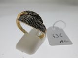 gros plan d'une bague sur une surface blanche avec une étiquette de prix